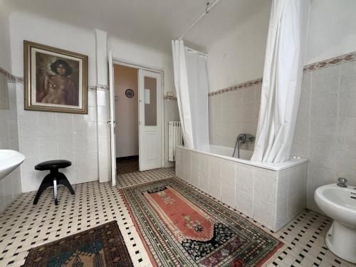 a bathroom with a tub and a toilet and a sink at Hostello Genovese in Genoa