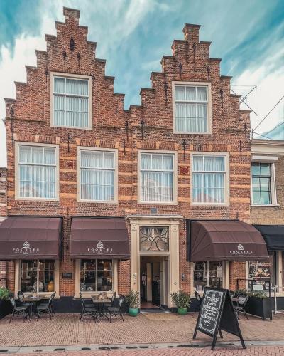 a brick building with tables and chairs in front of it at Poorter Boutique Hotel Brielle in Brielle