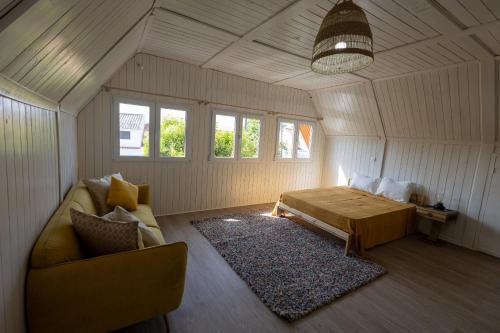 a bedroom with a bed and a couch in a room at Casa Feia Hostel in Costa da Caparica