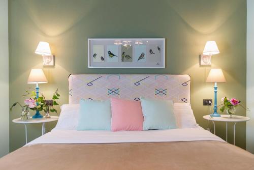 a bedroom with a bed with two tables and two lamps at Areela Boutique Hotel in Tirana