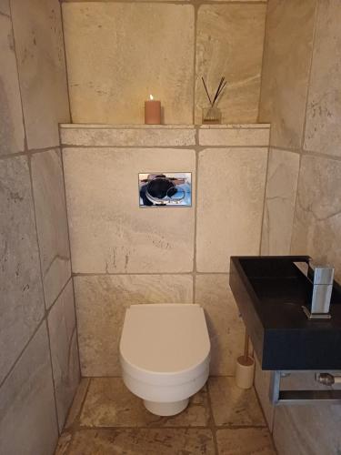 a small bathroom with a toilet and a candle at De Allerhof in Hattem