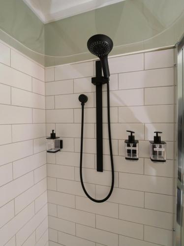 a shower with a black shower head in a bathroom at Leven Studio - StayTiny at Ulverstone in Ulverstone