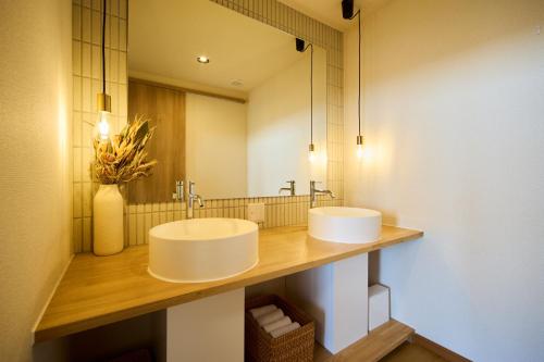 a bathroom with two sinks and a mirror at プライベートリゾート清風 in Atami