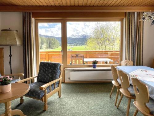 a room with a table and chairs and a large window at Chalet Cristall Superior Appartement 4 in Leutasch