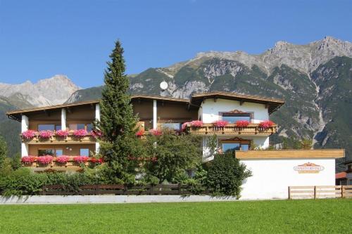 a building with flowers in front of a mountain at Chalet Cristall Superior Appartement 4 in Leutasch