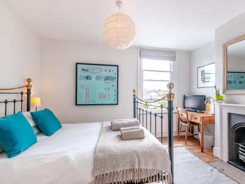 a bedroom with a bed with blue pillows and a desk at 3 Bed in Whitstable oc-wcc17 in Whitstable