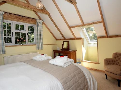 a bedroom with a bed and a chair and windows at 1 Bed in Etchingham oc-62641 in Burwash