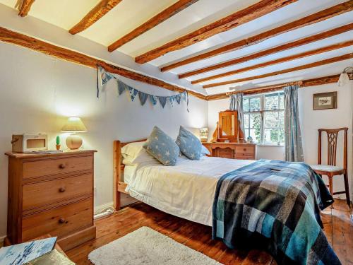 a bedroom with a bed and a dresser and a window at 1 Bed in Northiam oc-bt033 in Northiam
