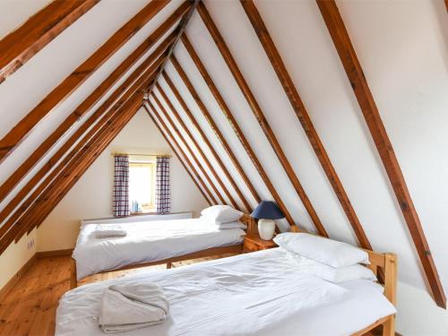 two beds in a attic room with wooden beams at 2 Bed in Briston oc-kt009 in Briston