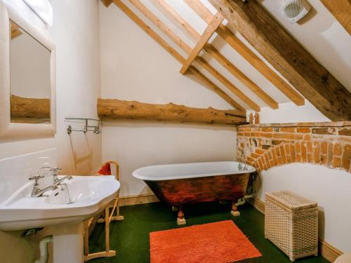 a bathroom with a bath tub and a sink at 3 Bed in Norwich oc-owln8 in Corpusty