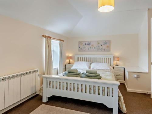 a bedroom with a white bed with green towels on it at 1 Bed in Wymondham oc-43278 in Wymondham
