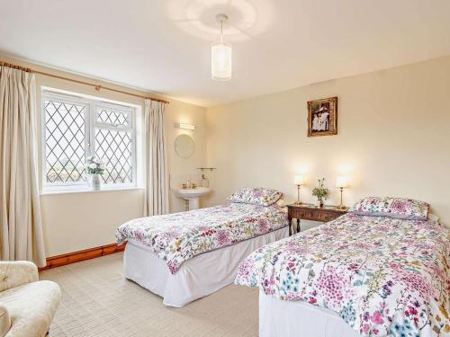 a bedroom with two beds and a sink and a window at 2 Bed in Dereham oc-57133 in Mattishall