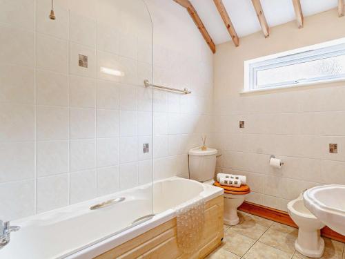 a bathroom with a tub and a toilet and a sink at 2 Bed in Dereham oc-57133 in Mattishall