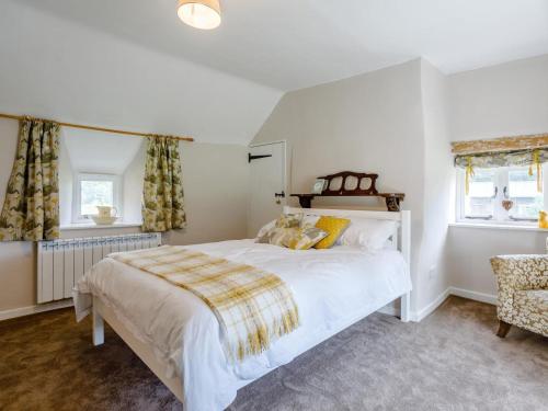 a bedroom with a large white bed and two windows at 1 Bed in Bedford oc-79095 in Turvey