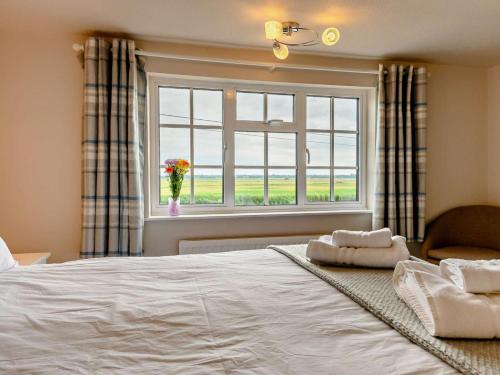 a bedroom with a large white bed and a window at 3 Bed in Norwich oc-47835 in Haddiscoe
