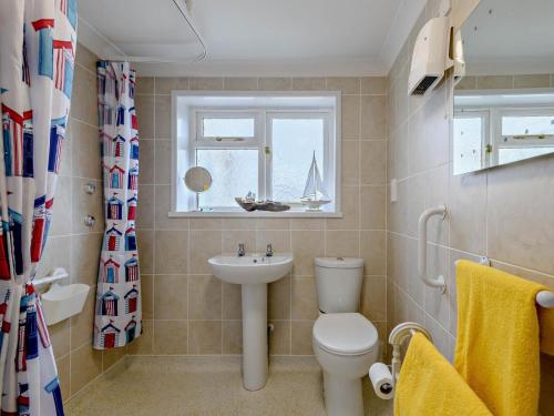 a bathroom with a toilet and a sink and a window at 2 Bed in Norwich oc-81322 in Walcott