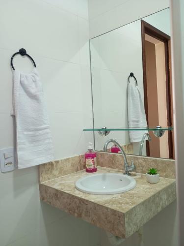 a bathroom counter with a sink and a mirror at Apartmento em Carapibus in Conde