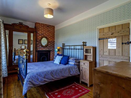 a bedroom with a blue bed and a fireplace at 2 Bed in Shereford oc-kt156 in Tatterford
