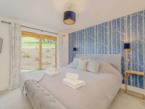 a large white bed in a room with blue wallpaper at 2 Bed in Montgomery oc-83244 in Llandyssil