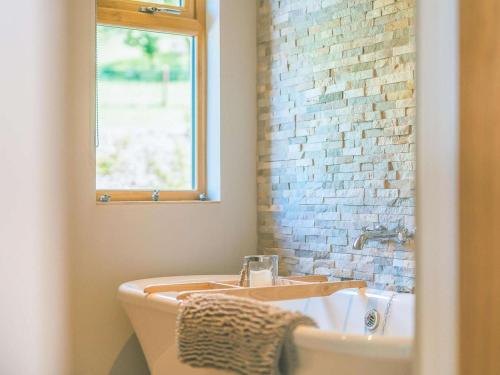a bathroom with a bath tub and a brick wall at 2 Bed in Montgomery oc-83244 in Llandyssil