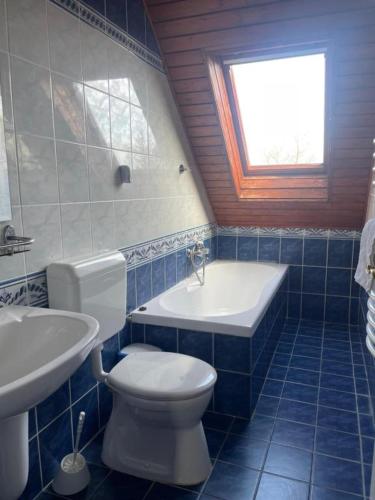 a bathroom with a toilet and a tub and a sink at Karikás Apartman in Hajdúszoboszló