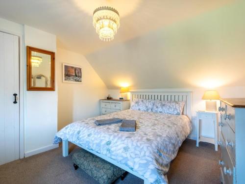 a bedroom with a large bed and a chandelier at 2 Bed in Syderstone oc-kt146 in Syderstone