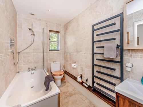 a bathroom with a tub and a toilet and a sink at 1 Bed in Chichester oc-77402 in Eastergate