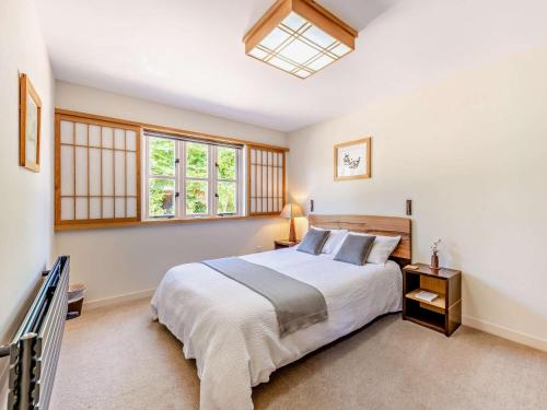 a bedroom with a large bed and two windows at 1 Bed in Chichester oc-77402 in Eastergate