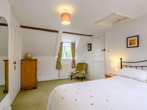 a bedroom with a bed and a chair and a window at 2 Bed in Field Dalling oc-kt007 in Saxlingham