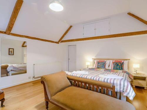 a bedroom with a bed and a chair at 5 Bed in Dereham oc-89542 in Swanton Morley