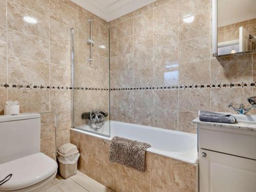 a bathroom with a tub and a toilet and a sink at 2 Bed in Norwich oc-75391 in Bacton