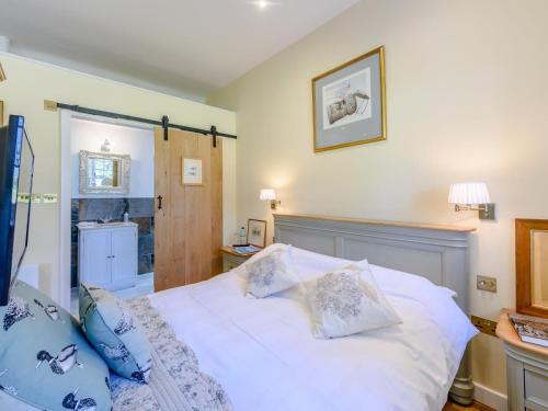 a bedroom with a white bed with blue pillows at 1 Bed in Lewes oc-79182 in Beddingham