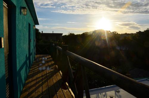 a view of the sun from a balcony of a house at La Brújula Hostel in La Paloma