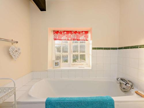 a white bath tub in a bathroom with a window at 2 Bed in Arundel oc-89671 in Arundel