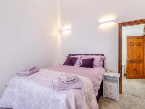 a bedroom with a bed with purple sheets and a mirror at 2 Bed in Lincoln oc-93058 in Saxilby