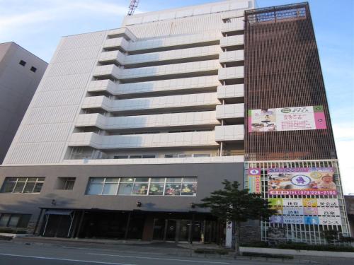a tall building with a sign in front of it at Hotel Crown Hills Himeji in Himeji