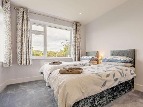 a bedroom with two beds and a window at 2 Bed in Mablethorpe oc-93143 in Trusthorpe