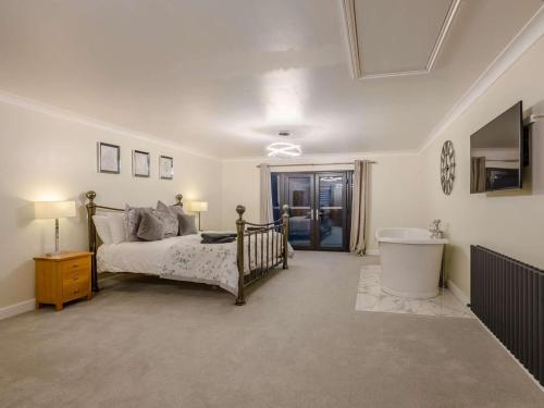a bedroom with a bed and a sink and a tub at 4 Bed in Norwich oc-90094 in Stratton Strawless