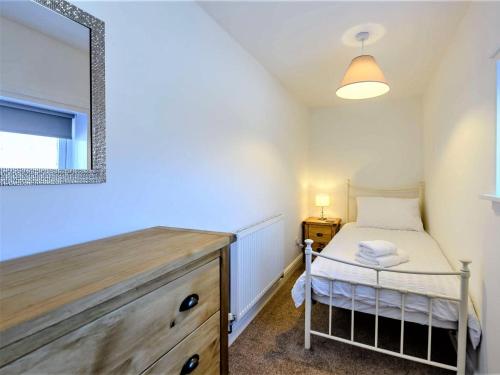 a small bedroom with a bed and a mirror at 4 Bed in Skegness oc-81343 in Wainfleet All Saints