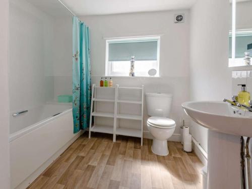 a bathroom with a toilet and a tub and a sink at 4 Bed in Skegness oc-81343 in Wainfleet All Saints