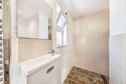 a white bathroom with a sink and a mirror at Casa Jardim in Loulé