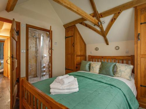 a bedroom with a green bed with towels on it at 2 Bed in Holt oc-ncc39 in Cley next the Sea