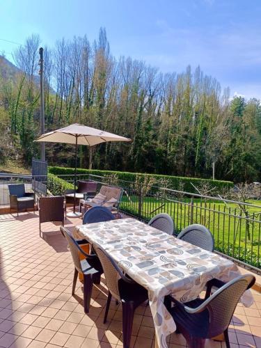 a patio with a table and chairs and an umbrella at Casa Fiocco vista Lago in Pisogne