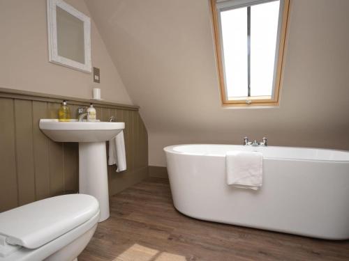 a bathroom with a tub and a sink and a toilet at 2 Bed in Alford oc-42581 in Ulceby