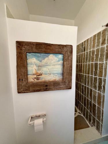 a painting of a ship on a wall in a bathroom at Flower House in Malindi