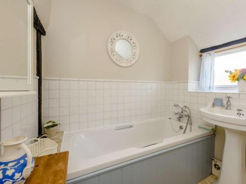 a white bathroom with a tub and a sink at 1 Bed in Battle oc-83845 in Sedlescombe