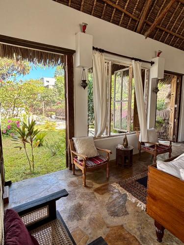 a living room with a view of a garden at Flower House in Malindi
