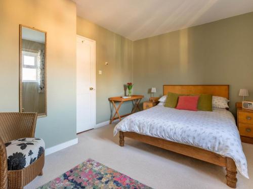 a bedroom with a bed and a chair and a mirror at 2 Bed in Colchester oc-42650 in Dedham