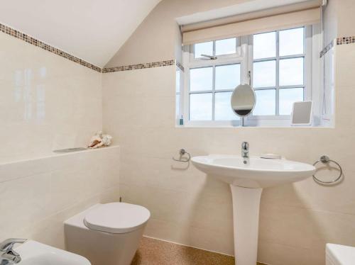 a bathroom with a sink and a toilet and a window at 3 Bed in Lincoln oc-90396 in Washingborough