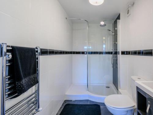 a white bathroom with a shower and a toilet at 3 Bed in Dereham oc-65903 in Foulsham